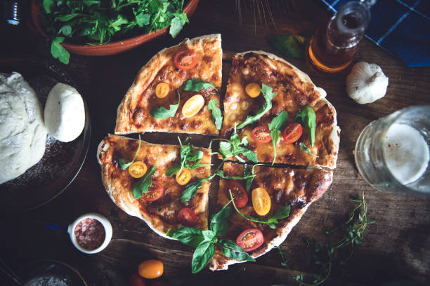 Italian pizza and pizza cooking ingredients on black concrete background