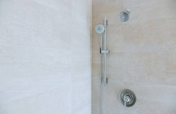 istock Modern shower head in bathroom with new home construction 1155489484