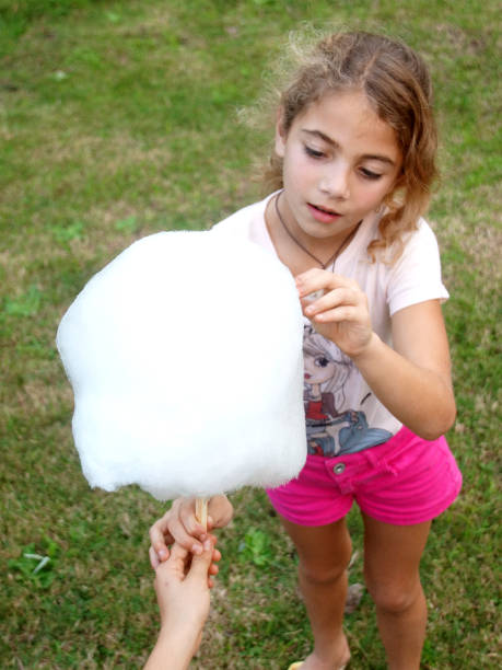 istock Girl Eating cotton candy 1155489935
