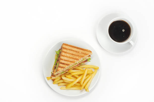 français frites sur une assiette blanche. a côté de la pomme de terre est un sandwich demi-club avec du jambon et du bacon. un café.  vue plongeante. - french toast toast coffee bread photos et images de collection