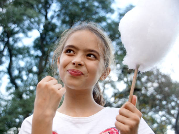 istock Girl Eating cotton candy 1155492531