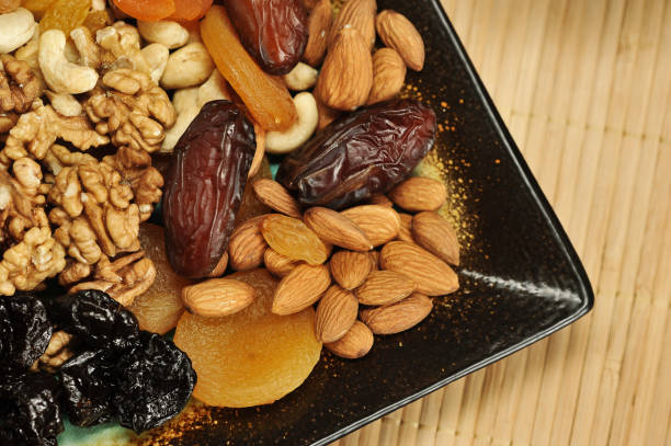 istock Dried fruits and nuts on a square plate. View from above. 1155492635