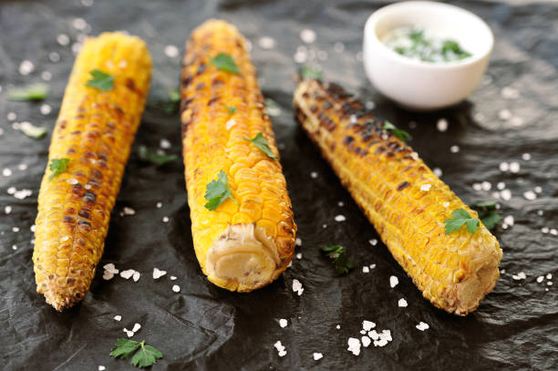 istock Three corn cobs cooked on the grill. Corn is sprinkled with herbs and large sea salt. 1155498193