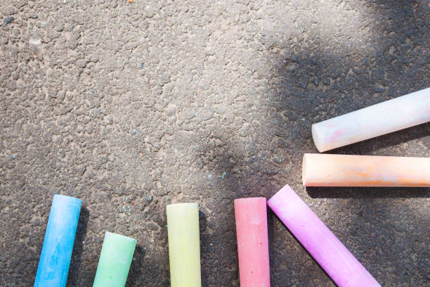 istock Colored chalk on asphalt. Children's creativity games. Background with place for text, frame, flat lay, copy space. Back to school. 1155500644