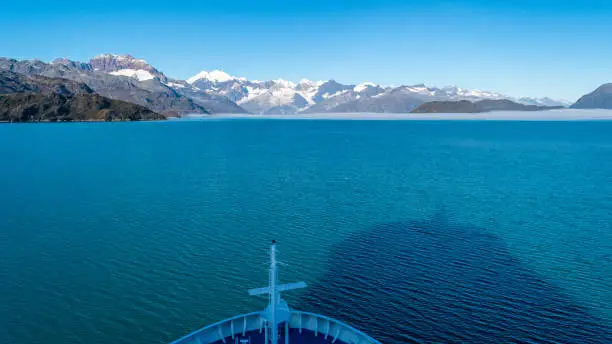 Cruise ship sailing in Glacier Bay National Park, Alaska. Breathtaking natural serene nature views. Spectacular sweeping vista of ice capped/ snow covered landscape of mountains, glaciers, wildlife.