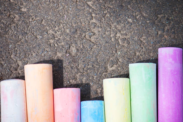 istock Colored chalk on asphalt. Children's creativity games. Background with place for text, frame, flat lay, copy space. Back to school. 1155500839