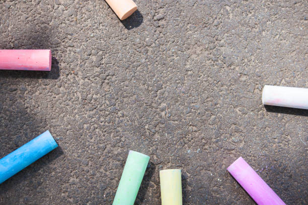istock Colored chalk on asphalt. Children's creativity games. Background with place for text, frame, flat lay, copy space. Back to school. 1155500841