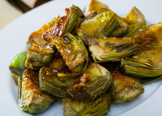 istock Appetizing artichokes fried in oil 1155504872