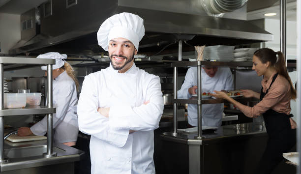 istock Positive chef of restaurant posing in kitchen 1155506316
