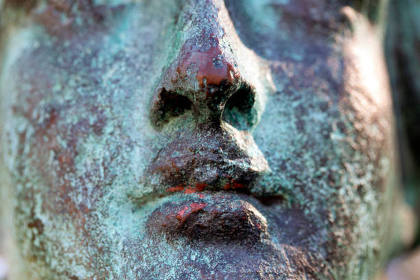 Closeup face of old bronze statue, background with copy space