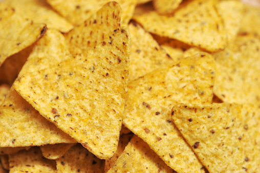 Mexican corn chips  occupy the entire frame space. Background image. Close-up. View from above. Macro photography.