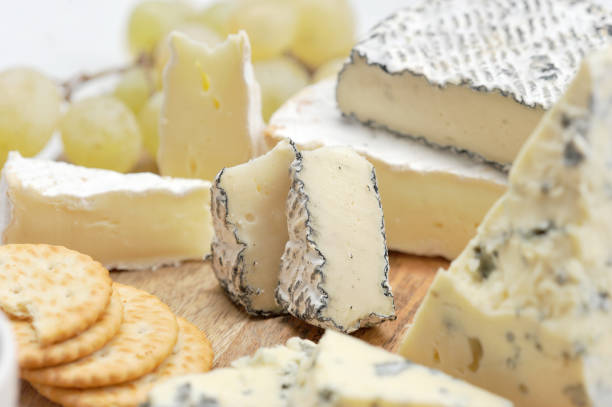istock Cheese plate: cheese with mold dorblu, crackers, grapes, camembert ashes, brie on a light wooden board. 1155508472
