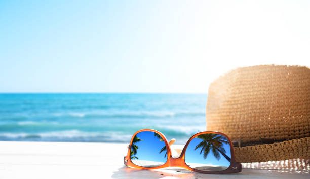 summer tropical beach background; glasses and palm tree reflex summer tropical beach background; glasses and palm tree reflex exotic vacations stock pictures, royalty-free photos & images