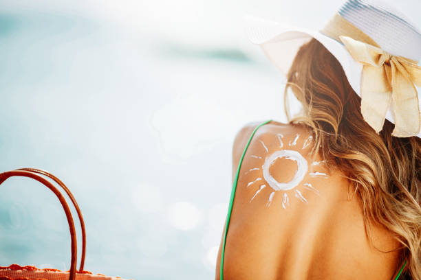beautiful woman at beach using sun lotion - summer people tourist slim imagens e fotografias de stock