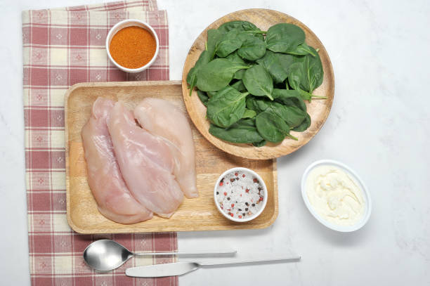 istock A set for cooking chicken breast stuffed with spinach and cottage cheese ricotta. Spinach, curd cheese, chicken fillet, spices.  View from above. 1155510210
