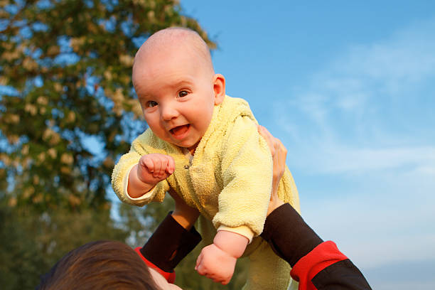baby in mother's arms against the background of sky