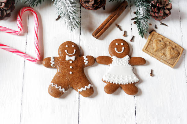 istock Gingerbread couple on white wooden background 1155514106