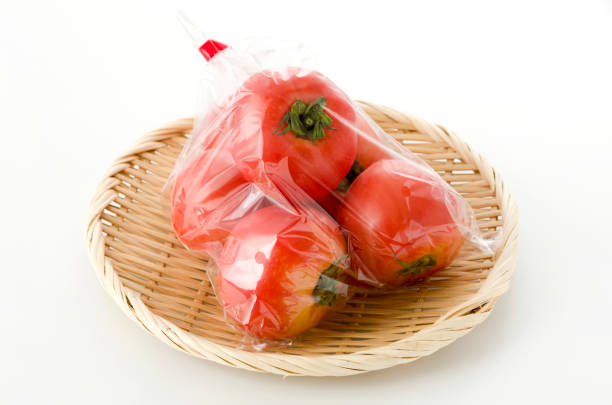 istock Ripe red Tomatoes in Plastic bag on bamboo colander 1155514329