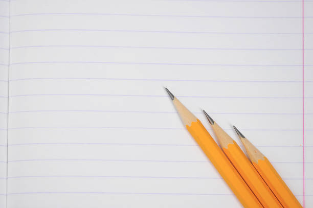 istock Notebook in the line. On a notebook sheet three pencils. View from above. 1155515942