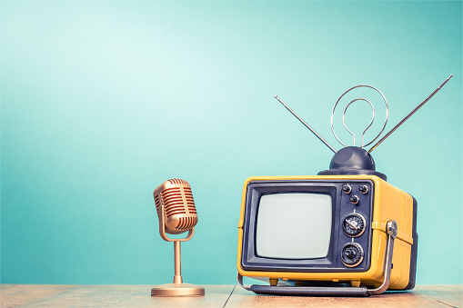 Retro viejo receptor de TV amarillo con antena y micrófono dorado en la mesa de madera de fondo de pared de aguamarina gradiente. Estilo de Instagram Vintage foto filtrada photo