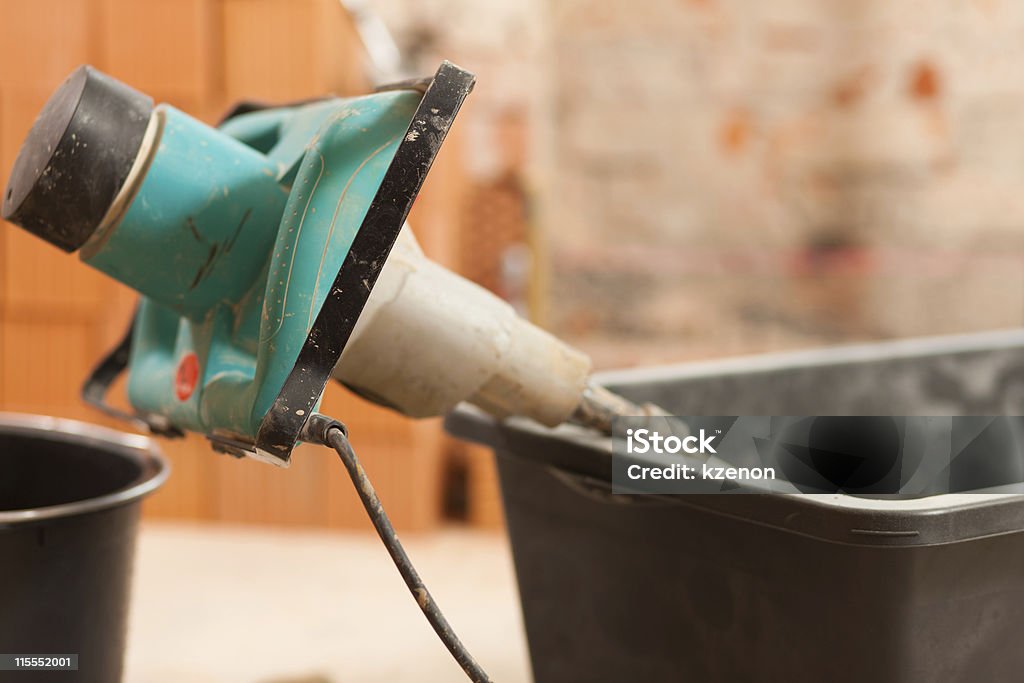 Hand mixer for mixing concrete Hand mixer on construction site for mixing concrete or grout Brick Stock Photo