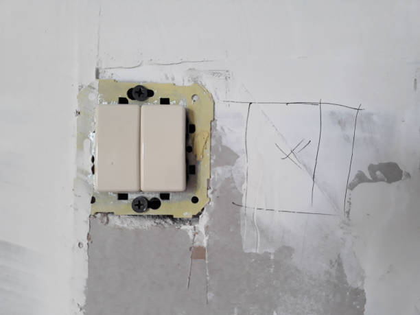 istock installing an electrical switch in a house under renovation on the wall 1155520083