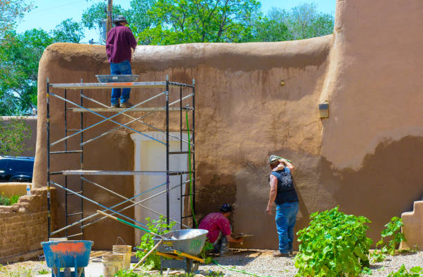 добровольцы, применяя adobe (грязь) к церковно�й стене - ranchos de taos стоковые фото и изображения