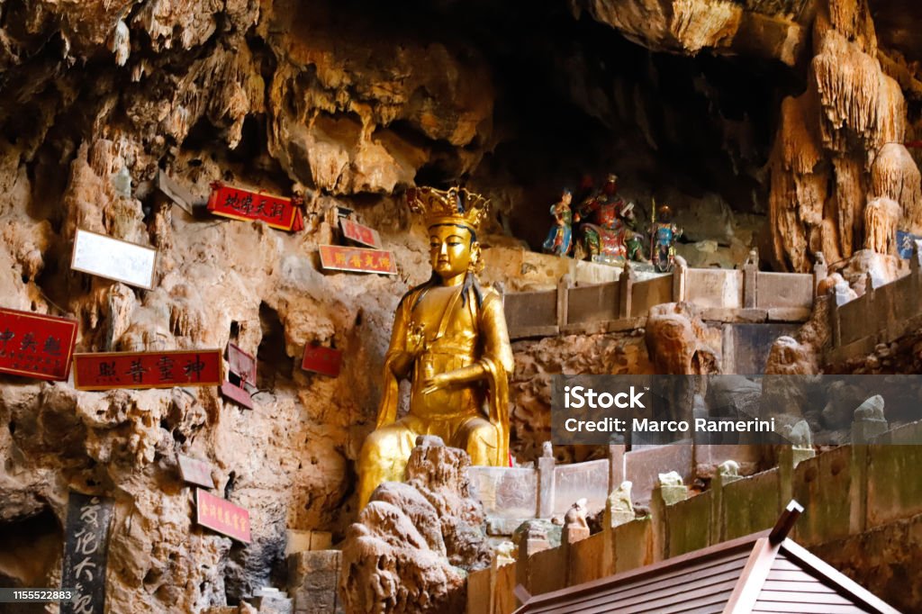 A statue of a god in Jianshui Swallow Cave in Yunnan, China A statue of a god in Jianshui Swallow Cave in Yunnan province, China. Yunnan, China - November, 2018 Cave Stock Photo