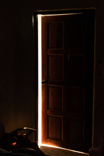istock bright warm light leaking from an opened door 1155523695