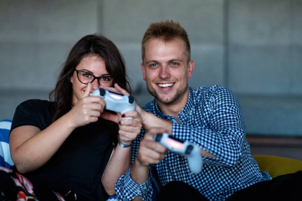 istock Young smiling couple playing videogames at home. 1155524673