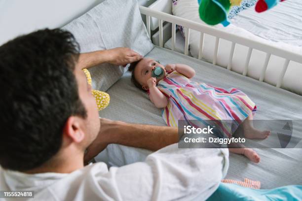 Padre Con Bebé Recién Nacido En El Dormitorio Foto de stock y más banco de imágenes de Bebé - Bebé, Dormir, Vista posterior