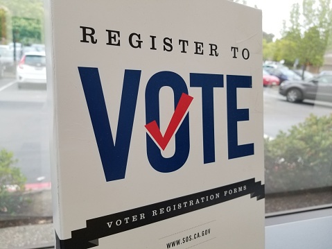 San Ramon, California, United States - May 18, 2019:  Sign reading Register to Vote and providing voter registration forms at a post office in San Ramon, California, May 18, 2019.