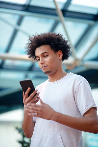 istock Young man looking away while talking on mobile phone in cafe 1155531841