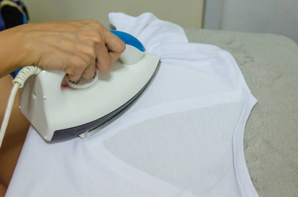 istock Woman hand holding the iron. 1155531959