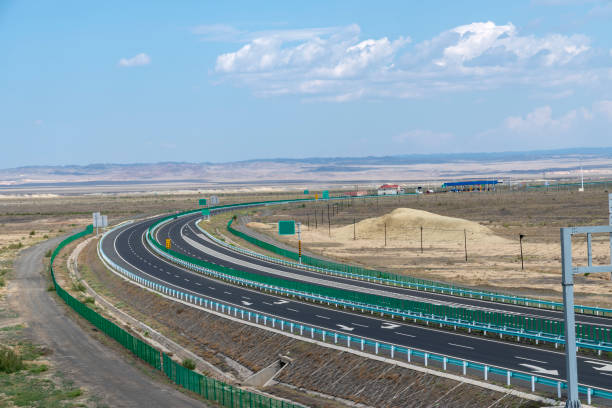 istock Highway perspective in blue sky and white clouds 1155531984