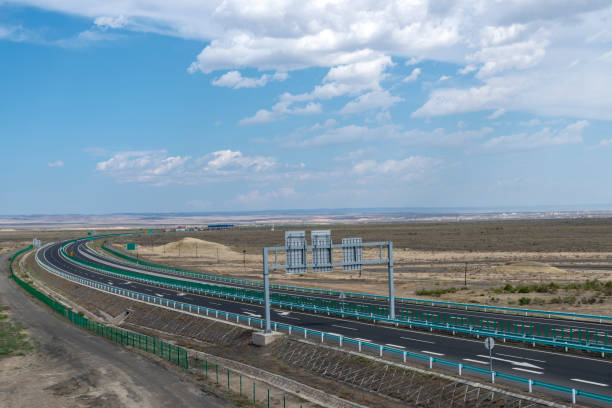 istock Highway perspective in blue sky and white clouds 1155531986