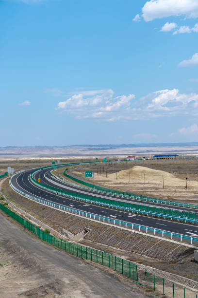 istock Highway perspective in blue sky and white clouds 1155531987