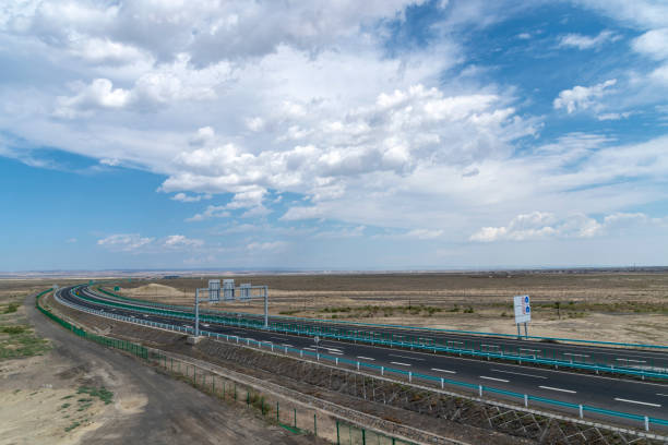 istock Highway perspective in blue sky and white clouds 1155531988