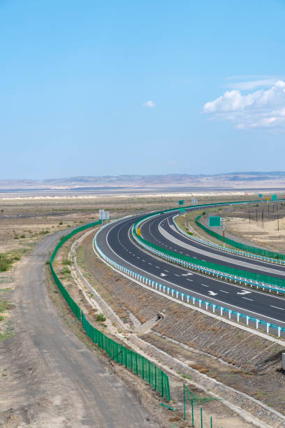 istock Highway perspective in blue sky and white clouds 1155532057