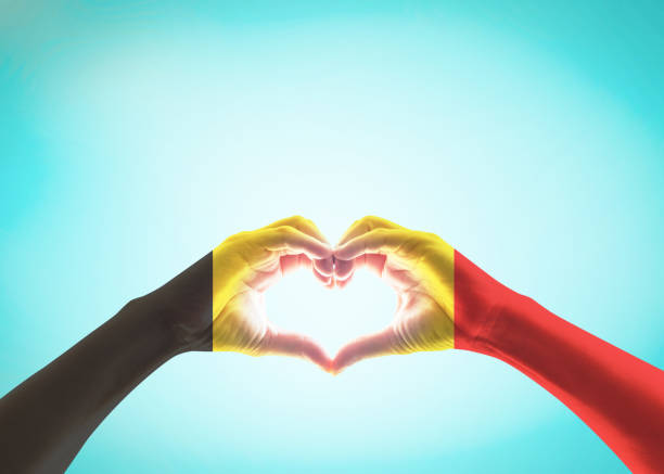 istock Belgian flag pattern on people heart shape hands (clipping path) on vintage background 1155532841