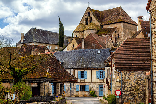 Creysse, a typical french village in Haut Quercy, Lot department, Martel, France, with traditional blue window shutters, brown brick buildings, tiled roofs and a roman church