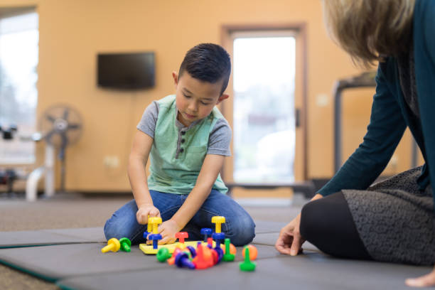 istock Occupational therapist works with a young ethnic boy 1155533365