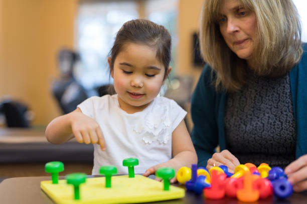 istock Occupational therapist works with a young ethnic girl 1155533369