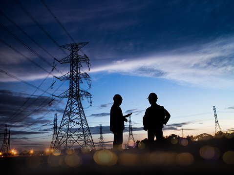 Silhouette of engineer and construction team working at site over blurred background for industry background with Light fair and bokeh. Create from multiple reference images together.