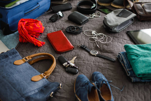 istock Man's and woman's daily accessories on bed ready for packing 1155534263