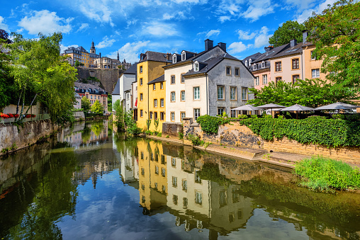 Luxembourg city, the capital of Grand Duchy of Luxembourg, view of the Old Town and Grund reflecting in Alzette river on a sunny summer day