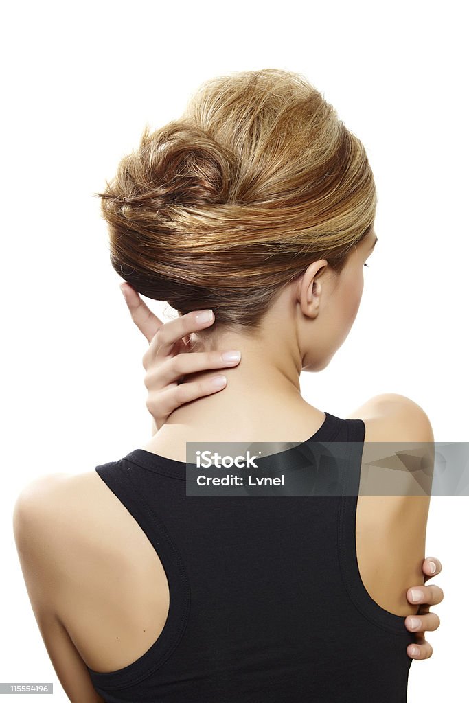 beautiful woman with blond hair beautiful woman with blond hair in french roll wearing little black dress touching her neck view from the back on white 20-29 Years Stock Photo