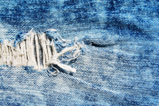 istock Denim texture.Blue jeans with threads and holes for the background 1155546916