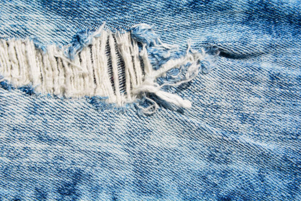 istock Denim texture.Blue jeans with threads and holes for the background 1155546922