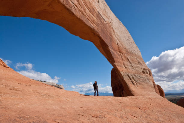 istock Woman Standing Under Wilson Arch 1155557866